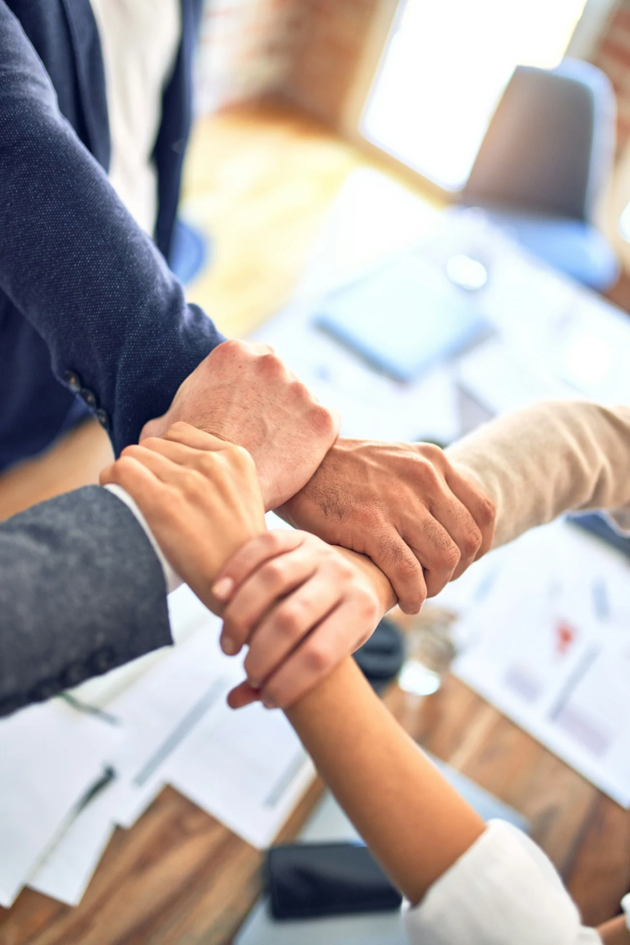 Business partners joining hands over a desk